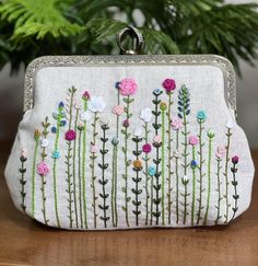 a hand embroidered purse with flowers on it