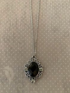 "This rich and sophisticated oval shaped necklace in tibetan silver and black has an intricately designed edging with a black crystal center stone and 4 rhinestone accents.  Pendant measures 1 3/8\" L X 1\" W and is on an 18\" chain.    ★ Want to see more?  Please visit my shop at: https://www.etsy.com/shop/DesignsByPeg" 90s Black Necklace, Black Gem Jewelry, Black Gem Necklace, Black Necklace Aesthetic, Black Jewelry Aesthetic, Necklace With Black Stone, Black And Silver Jewelry, Black Stone Jewelry, Crystal Necklace Black