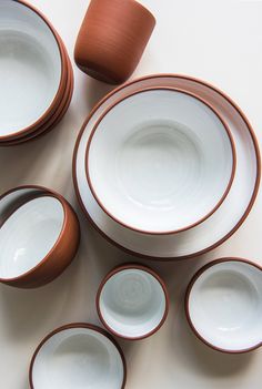 a table topped with lots of white and brown dishes