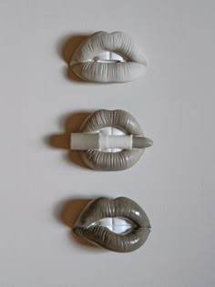 three fake lips are mounted on the wall