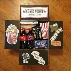 an open box filled with movies and drinks on top of a wooden floor next to a bottle