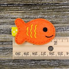 an orange fish is sitting on top of a ruler