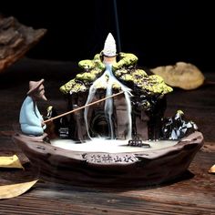 a figurine is sitting on top of a boat with water coming out of it