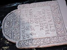 a stone with writing on it sitting on top of a plastic wrapper in front of a black background