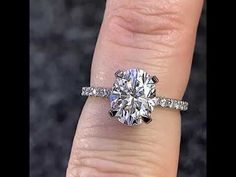 a woman's hand with a diamond ring on top of her finger and an engagement band