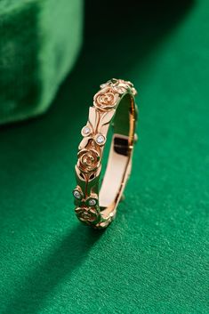 a close up of a gold ring on a green surface with a cloth in the background