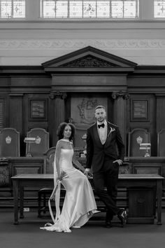 a man and woman in formal wear standing next to each other at a church altar