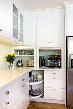 a kitchen with white cupboards and stainless steel refrigerator freezer combo in the corner