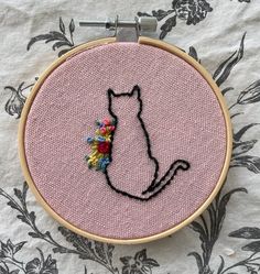 a cat with a pompom on it's tail sitting in a hoop