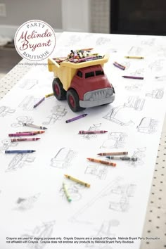 there is a toy truck with crayons on the table next to pencils