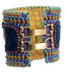 Introducing the **De Petra Signature Cuff Bracelet**, a masterpiece of artisanal craftsmanship that epitomizes elegance and individuality. Each bracelet is a labor of love, meticulously handcrafted over a span of three to four days by the artist herself, ensuring that no two pieces are ever alike. The creation process begins with the selection of the finest Italian leather, known for its unparalleled quality and luxurious texture. The leather forms the foundation of the cuff, carefully cut and shaped to embrace the wrist with comfort and style. The rich, earthy tones of the leather exude sophistication, setting the stage for the layers of artistry to come. Next, a layer of sumptuous silk velvet is hand-stitched onto the leather. This velvet, with its soft, plush feel, adds a touch of opule Handmade Ceremonial Bracelets, Luxury Handmade Ceremonial Bracelets, Designer Cuff Bracelet Bangle As Gift, Luxury Handmade Cuff Bracelet For Formal Occasions, Designer Bangle Cuff Bracelet, Luxury Handmade Ceremonial Bangle, Luxury Handmade Formal Cuff Bracelet, Luxury Adjustable Jubilee Cuff Bracelet, Bohemian One-of-a-kind Cuff Bracelet