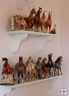 there are many toy horses on the shelves