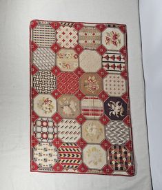 a red and white quilt with many different designs on it