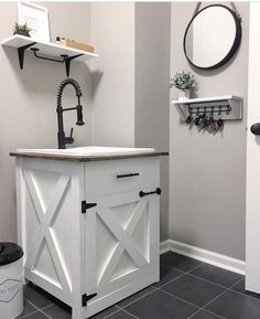 a bathroom with a sink, mirror and shelving unit