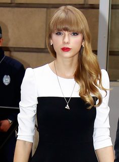 a woman with long blonde hair wearing a black and white dress