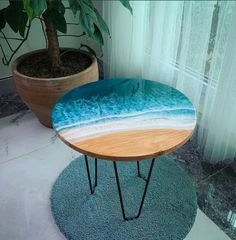 a wooden table sitting on top of a blue rug next to a potted plant