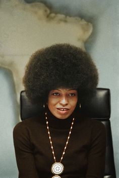 a woman with an afro sitting in a chair