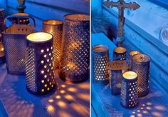 there are many lit candles sitting on the ground next to each other and one has a cross in it