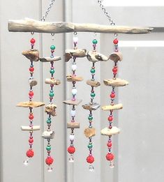 a wind chime hanging from a tree branch with beads and wood pieces on it