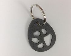 a metal keychain with an animal paw print on it's front side