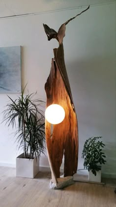 a lamp that is sitting on top of a wooden table next to potted plants