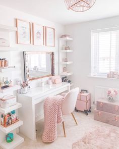 a white desk with a pink chair in front of it and pictures on the wall