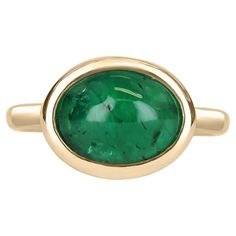 A bezel-set emerald cabochon ring in 14K yellow gold. Featured here is this lovely 4.77-carat natural, earth-mined, emerald cabochon. This stone displays a gorgeous, dark green color, and very good luster. This natural beauty is set in a 14K yellow gold bezel setting. Setting Style: Bezel / Solitaire set Setting Material: 14K Yellow Gold Gold Weight: 5.3 Grams Main Stone: Emerald Cabochon Shape: Oval Cut Weight: 4.77-Carats Clarity: Translucent Color: Dark Green Luster: Very Good Origin: Zambia Emerald Cabochon, Emerald Gem, Dark Green Color, Solitaire Setting, Colombian Emeralds, Cabochon Ring, Unisex Jewelry, Natural Earth, Pinky Ring