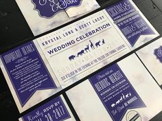 purple and white wedding stationery is displayed on the wall in front of other items