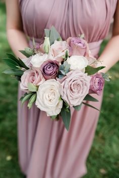 a bridesmaid holding a bouquet of flowers in her hands