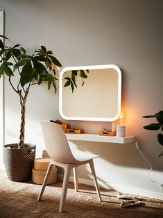 a white desk with a mirror on it next to a potted plant