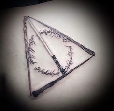 a harry potter triangle tattoo on the back of a woman's upper arm and shoulder