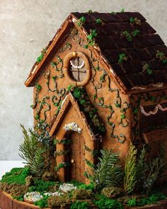 a gingerbread house is decorated with greenery