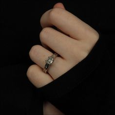 a woman's hand with a diamond ring on it