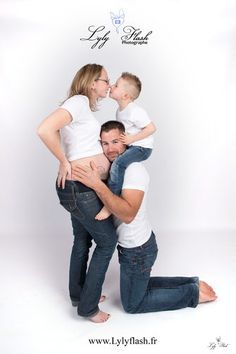 a man and woman holding a small child in their arms while posing for the camera