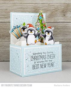 a christmas card with penguins in a box