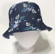 Bucket hat made of lightweight denim with blue and white floral print. Reverses to a blue and white polka dot print. Size MEDIUM, with 2-1/2 inch slot for ponytail. Foldable and lightweight to help keep you cool. Great for outdoor concerts, floating in the pool, yardwork, beach trips, resort stay or vacation travel. 100% cotton. Handmade in the USA. Hat With Flowers, Floral Bucket Hat, Gardening Hat, Denim Bucket Hat, Festival Hat, Outdoor Concert, Beach Trips, Fishing Women, Fishing Hat