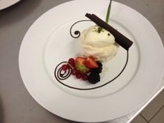 a white plate topped with ice cream and fruit