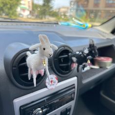 a car dashboard with a stuffed animal in the center console and other items on the dash board