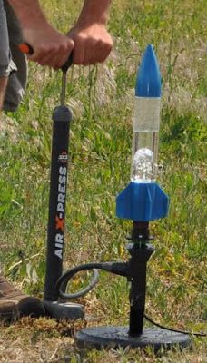 a man is working on an electric device in the grass with a light attached to it