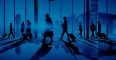 silhouettes of people walking through an airport terminal