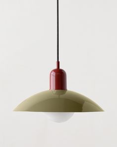 a red and white light hanging from a ceiling fixture with a black cord in front of it