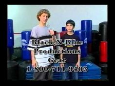 two young boys standing next to each other in front of blue and red barrels with the words black - n - blue production gear