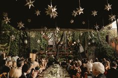 a group of people sitting around a table under stars hanging from the ceiling above them