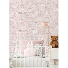 a baby's room with pink wallpaper and a teddy bear on the bed