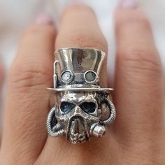 Product Description: Introducing the Steampunk Skull Ring - a handmade biker ring that exudes unique appeal! This stunning piece of jewelry is made with 925 sterling silver, weighing in at around 29 grams. Created by a skilled artisan in Cyprus, this ring showcases a striking steampunk design that is sure to impress. The adjustable sizing ensures a perfect fit for any finger.  Highlights: - Handmade item from a small business in Greece  - Made with high-quality 925 sterling silver - Unique and b Gothic Wardrobe, Steampunk Skull, Biker Ring, Sterling Silver Skull Rings, Silver Skull Ring, Style Steampunk, Biker Rings, Steampunk Design, Everyday Accessories