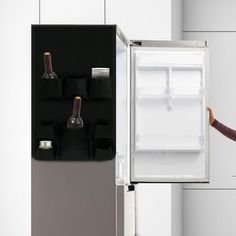 a woman standing in front of a refrigerator with the door open and wine glasses hanging on it