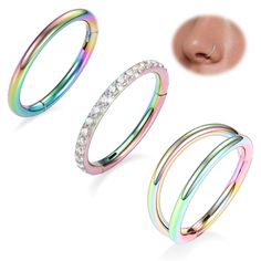 three different colored rings with crystal stones on each side and a nose ring in the middle