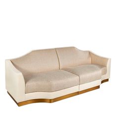 a white and gold couch sitting on top of a white floor next to a wall