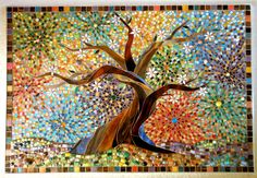 a tree made out of stained glass and mosaic tiles is displayed on the wall in this room