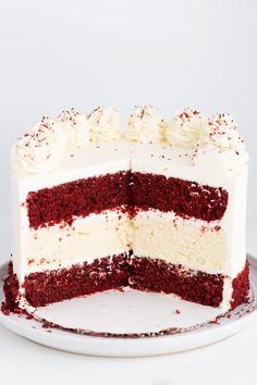 a red velvet cake with white frosting and sprinkles on a plate